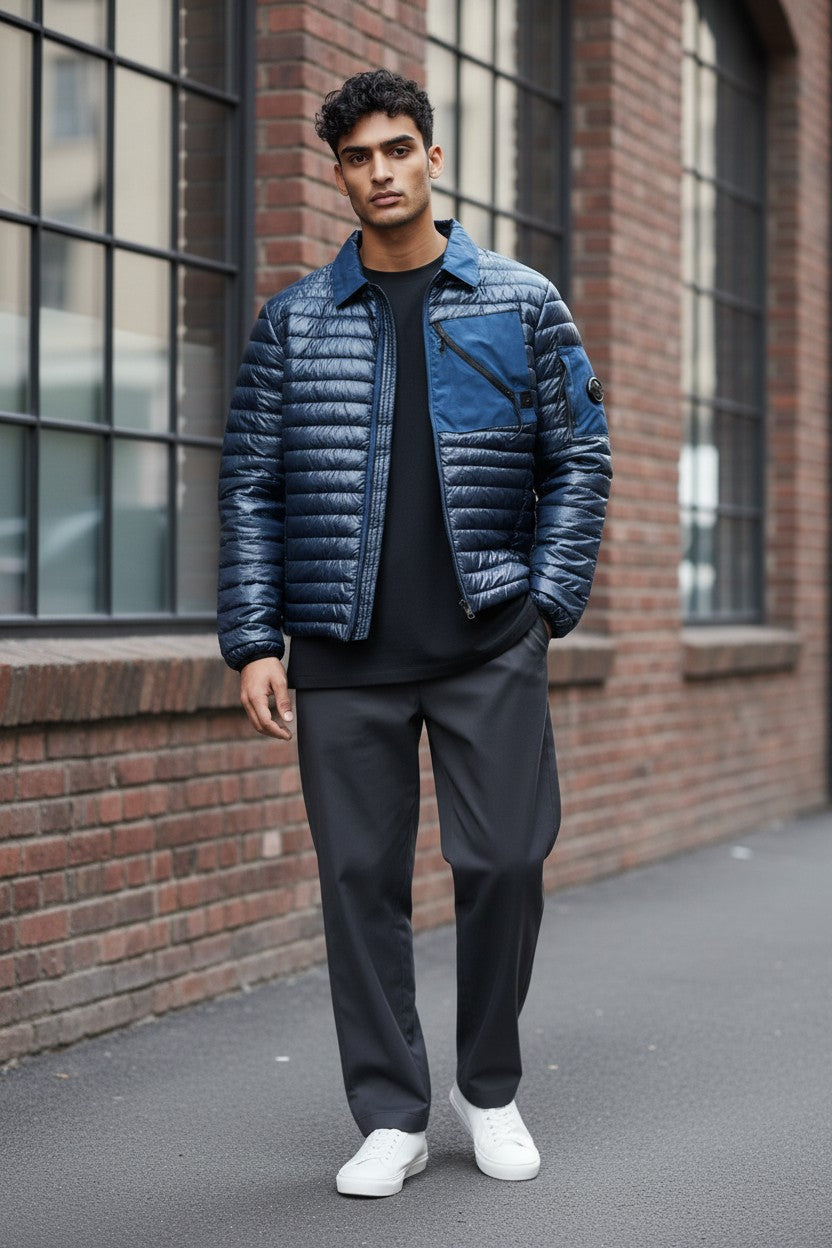 Archive No. 9 blue C.P. Company DD Shell bomber jacket with down filling and signature lens detail on sleeve.