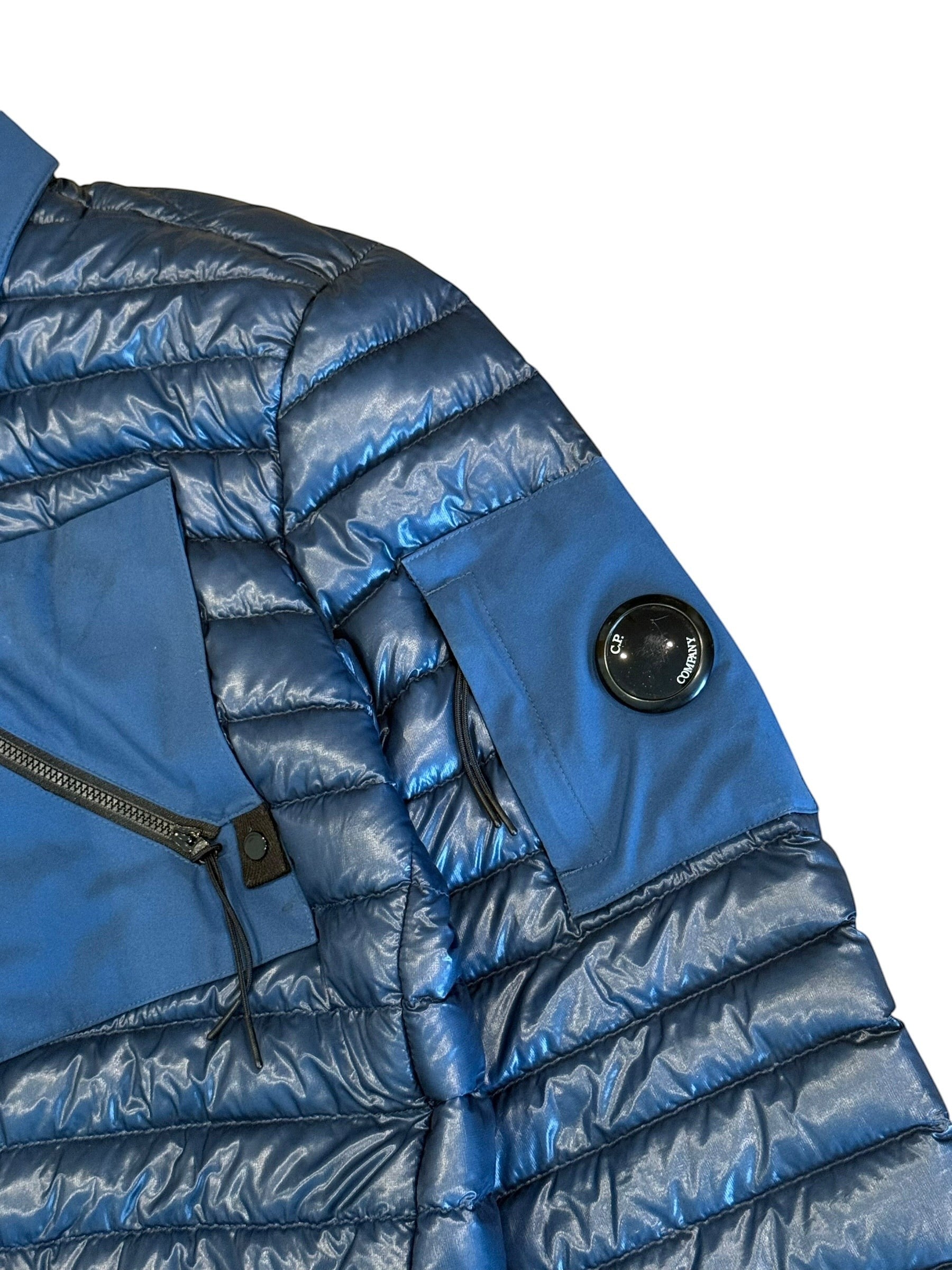 Archive No. 9 blue C.P. Company DD Shell bomber jacket with down filling and signature lens detail on sleeve.