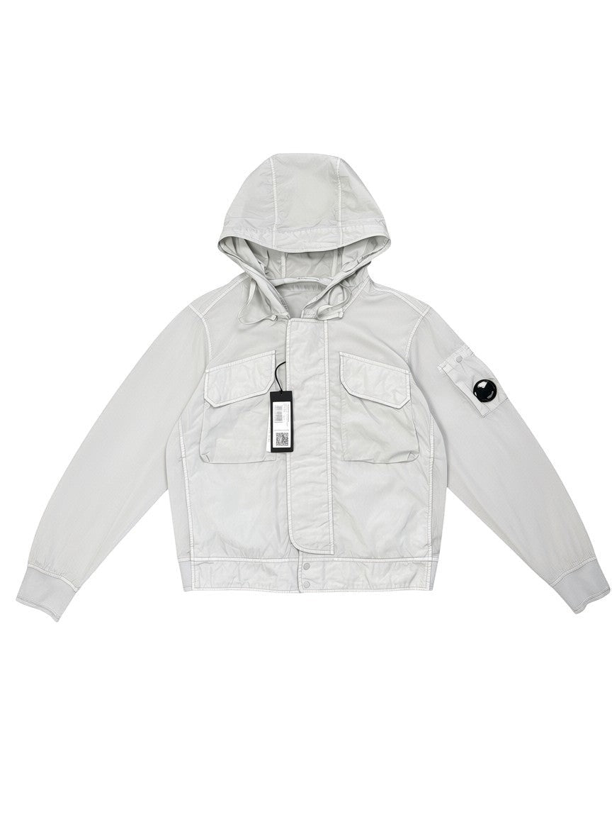 Archive No. 9 C.P. Company light blue Chrome R Utlity Windbreaker jacket with hood, two chest pockets, and lens logo on sleeve. Size L.