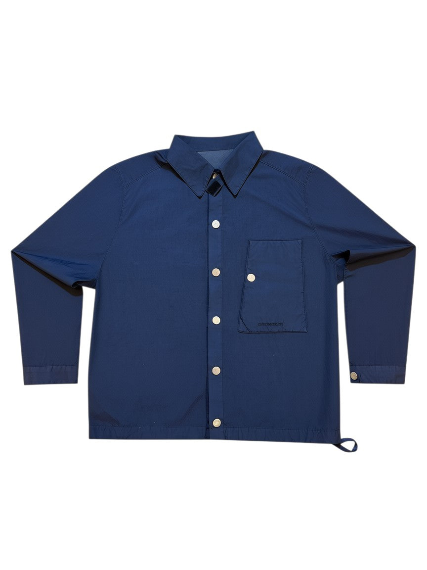 Archive No. 9 navy blue C.P. Company shell overshirt jacket with button-up front and chest pocket logo. Waterproof and wind-resistant.