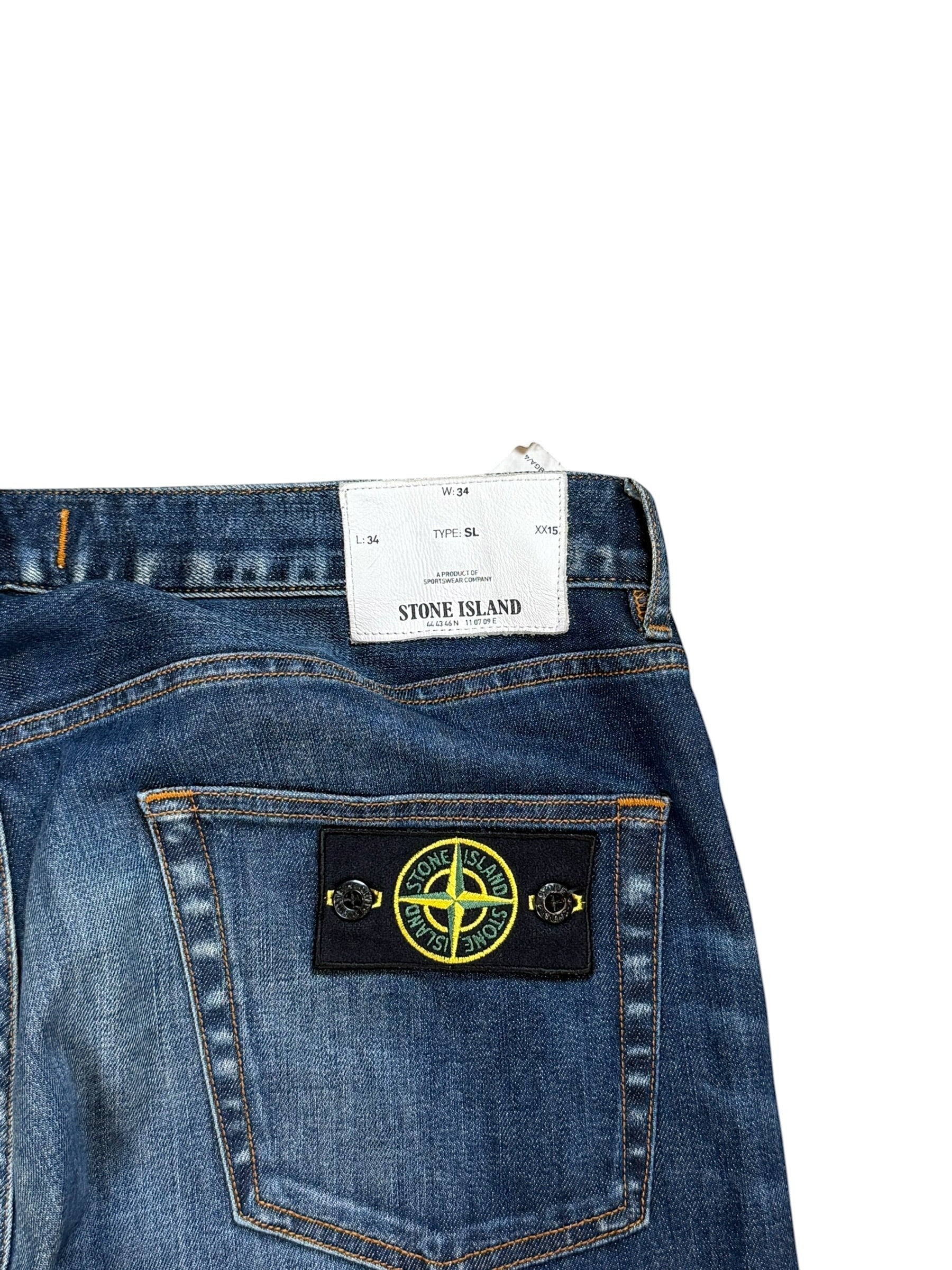 Archive No. 9 vintage navy blue denim jeans with Stone Island compass badge on back pocket. Size W34.