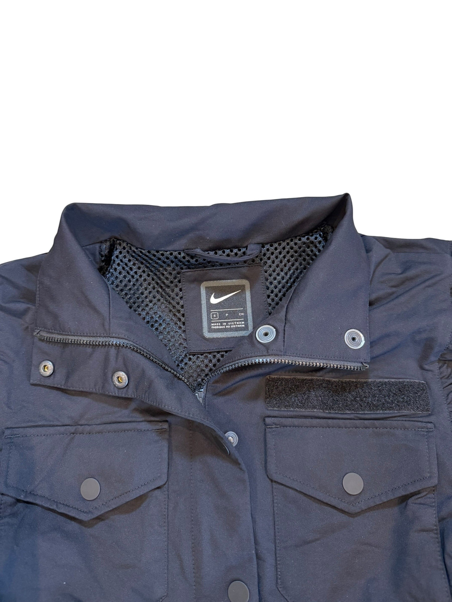 Archive No. 9 Nike black utility jacket with elasticated exterior, mesh lining, and two chest pockets. Size Small.
