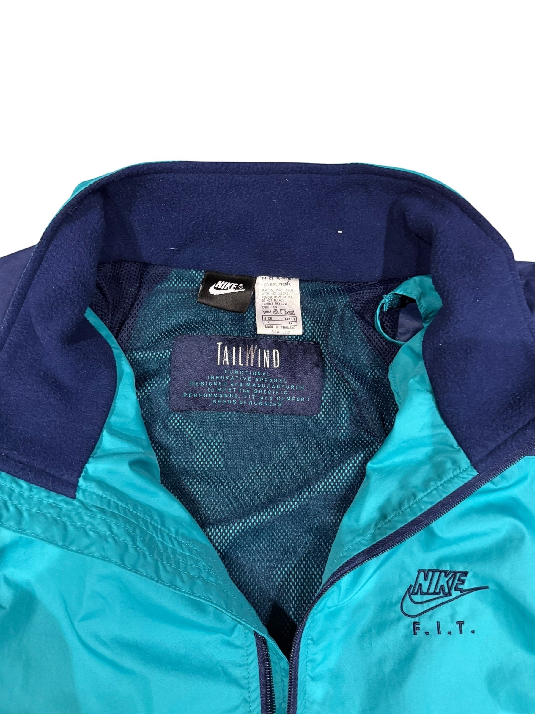 Archive No. 9 Nike windbreaker in turquoise and purple, size Large. Lightweight, wind-resistant, and waterproof.
