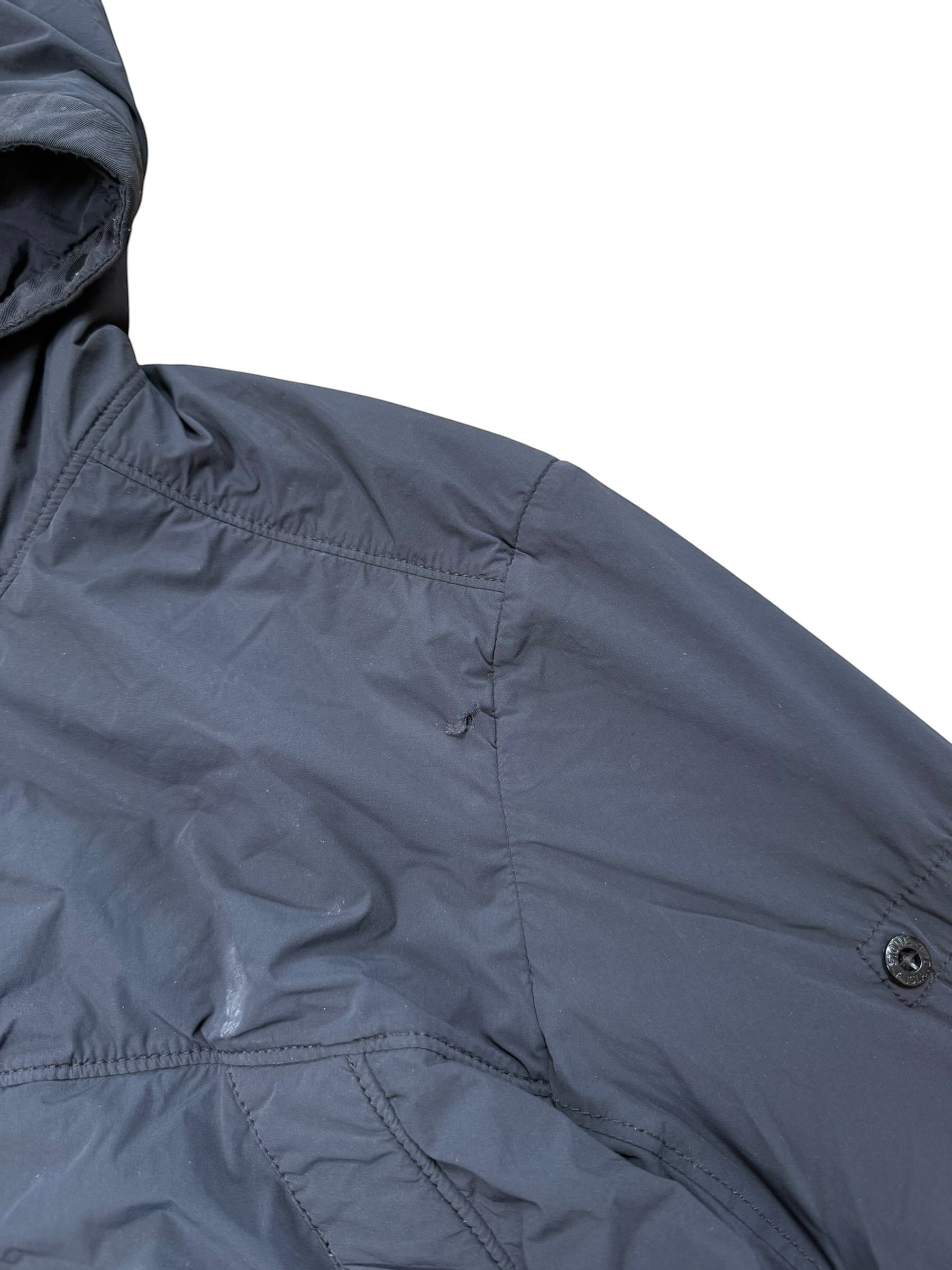Archive No. 9 black Stone Island comfort tech composite jacket with elasticated cuffs and waist, showing a small tear on the front.
