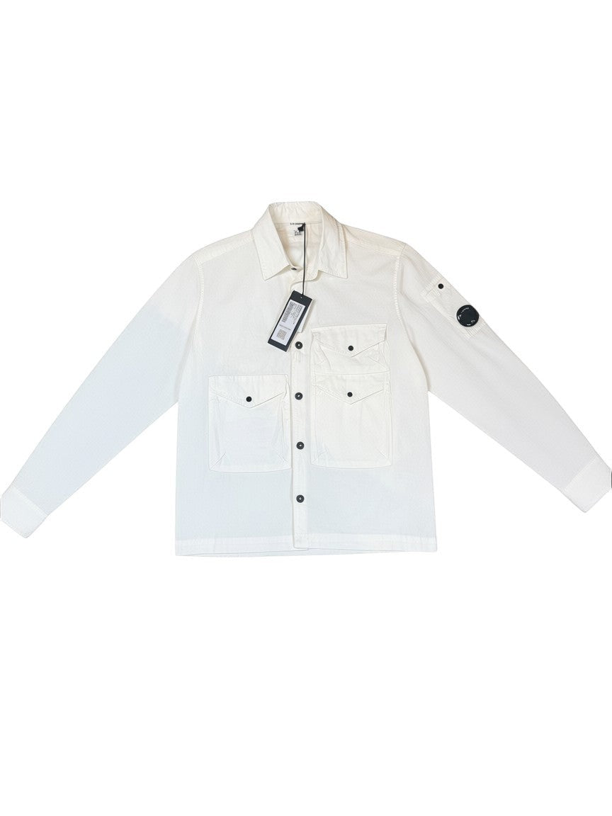 Archive No. 9 white C.P. Company lightweight overshirt with button-up front, chest pockets, and iconic arm lens detail.